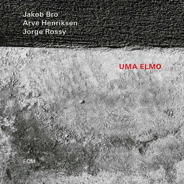 Album borító. Absztrakt szürke és fehér textúrák a 'UMA ELMO' szavakkal pirossal és előadók neveivel.