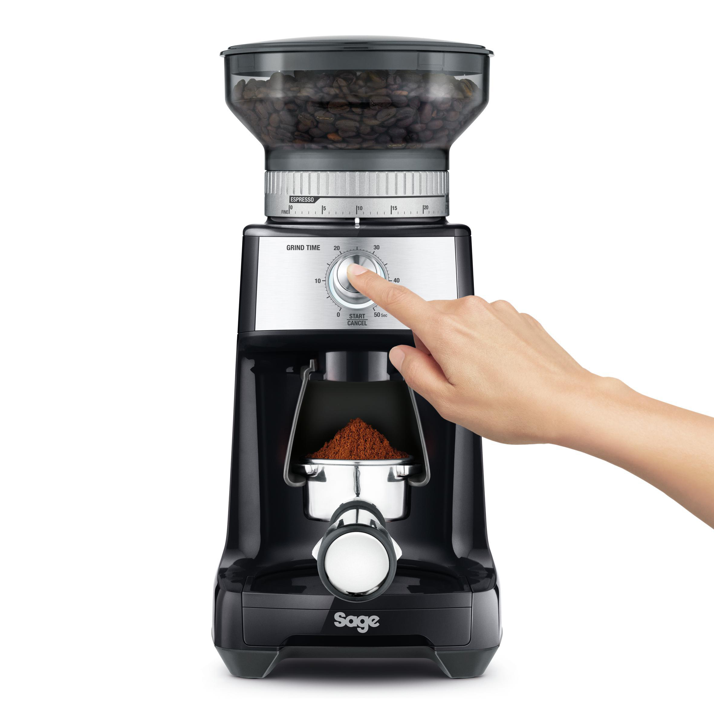 Schwarze Kaffeemühle mit einer Hand, die ein Zifferblatt dreht.