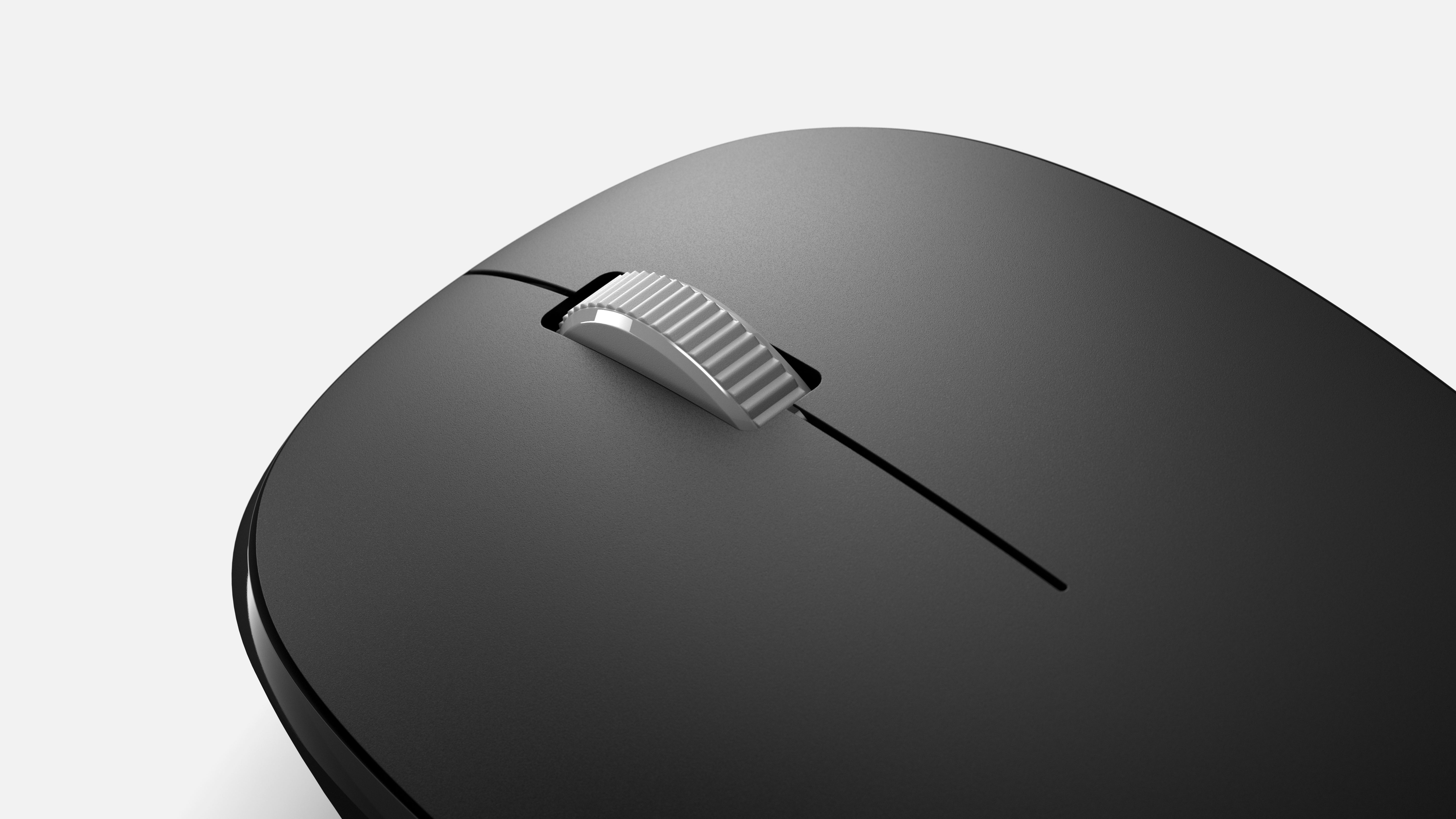 Siyah kablosuz bilgisayar faresinin yakın çekimi. Ortada kaydırma tekerleği, siyah yüzey ve beyaz arka plan.