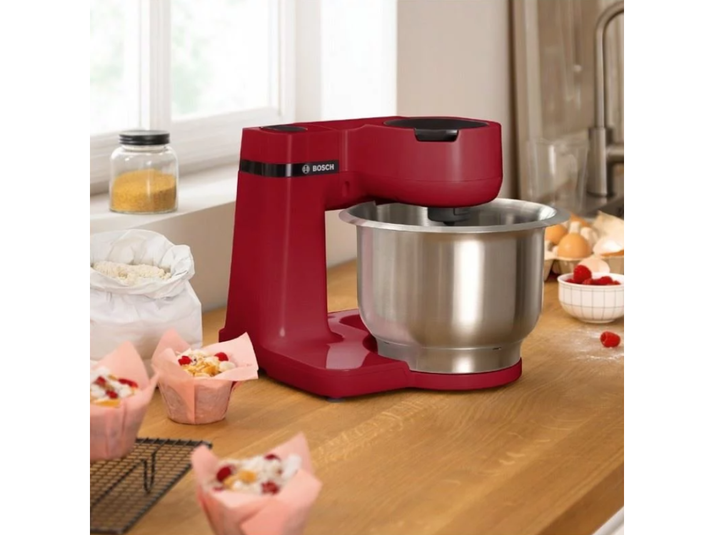 Batidora de cocina Bosch roja con un bol de acero inoxidable, magdalenas y harina.