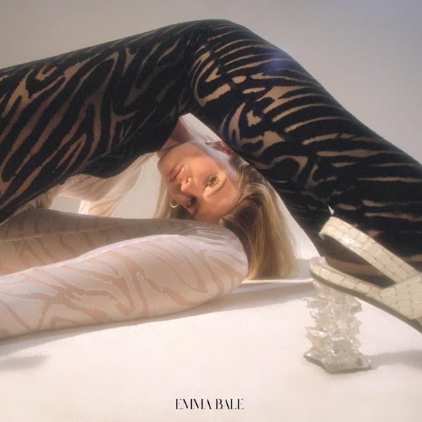 Vrouw in leggings en top met patroon, liggend op een oppervlak.