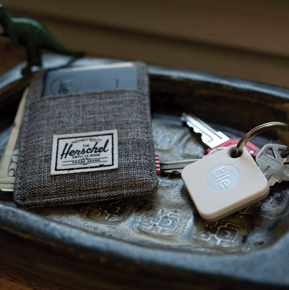Wallet and keys on a tray, with a Tile tracker.