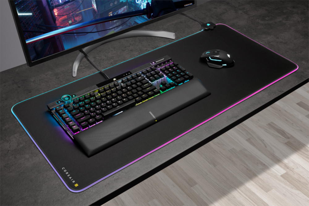 Une configuration de jeu avec un clavier, une souris et un tapis de souris avec une bordure lumineuse RVB sur le bureau.