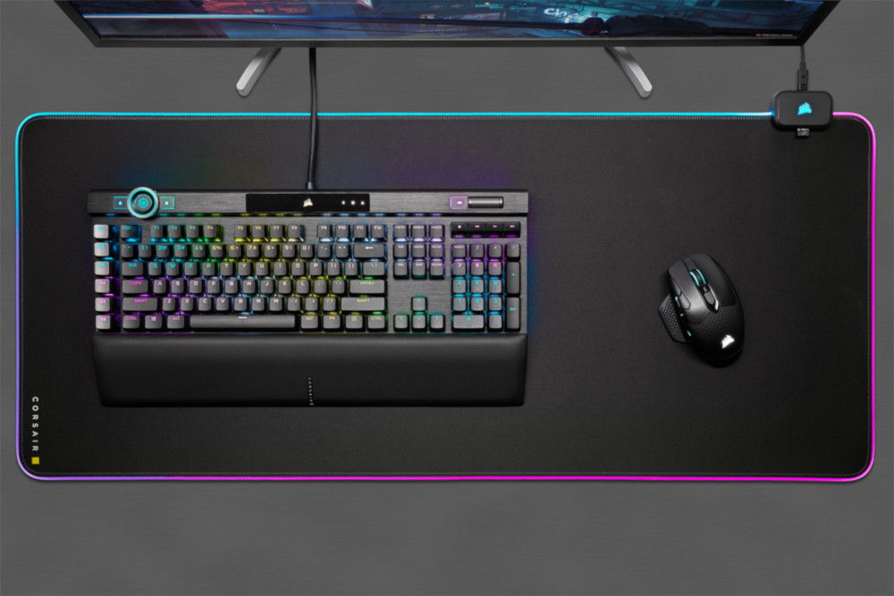 Un clavier et une souris sur un tapis de souris Corsair noir, avec des lumières.
