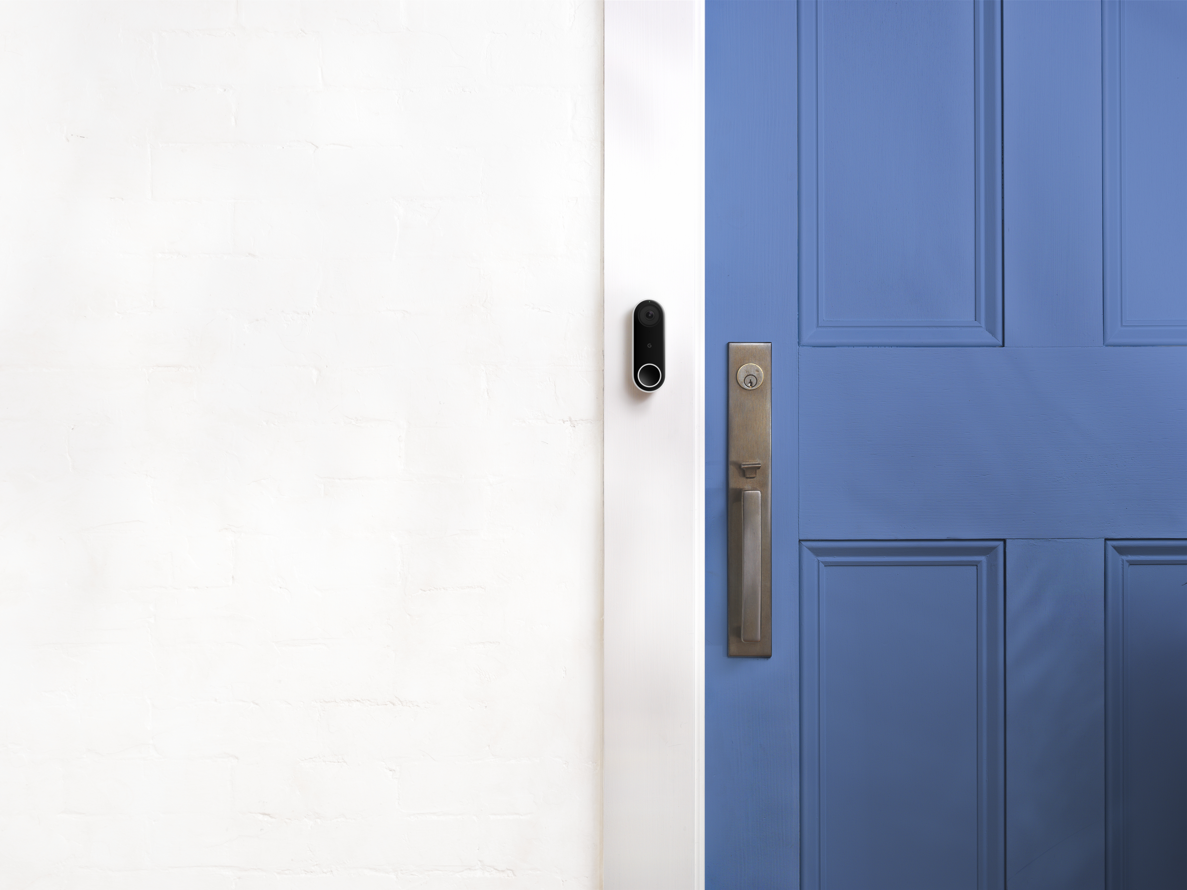 Weiße Wand und blaue Tür mit Türklingel.