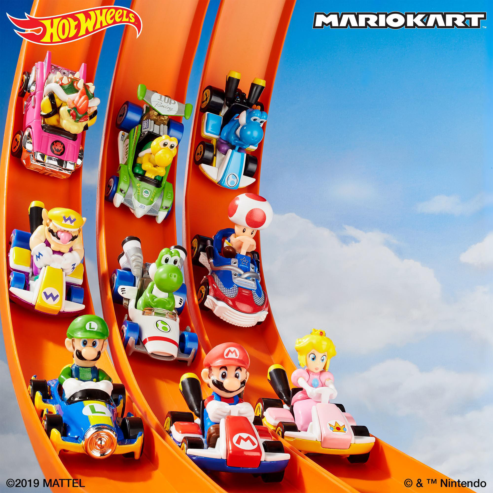 Mario Kart Hot Wheels-Rennwagen auf einer orangefarbenen Rennstrecke vor blauem Himmel. Charaktere sind Mario, Luigi und Peach.