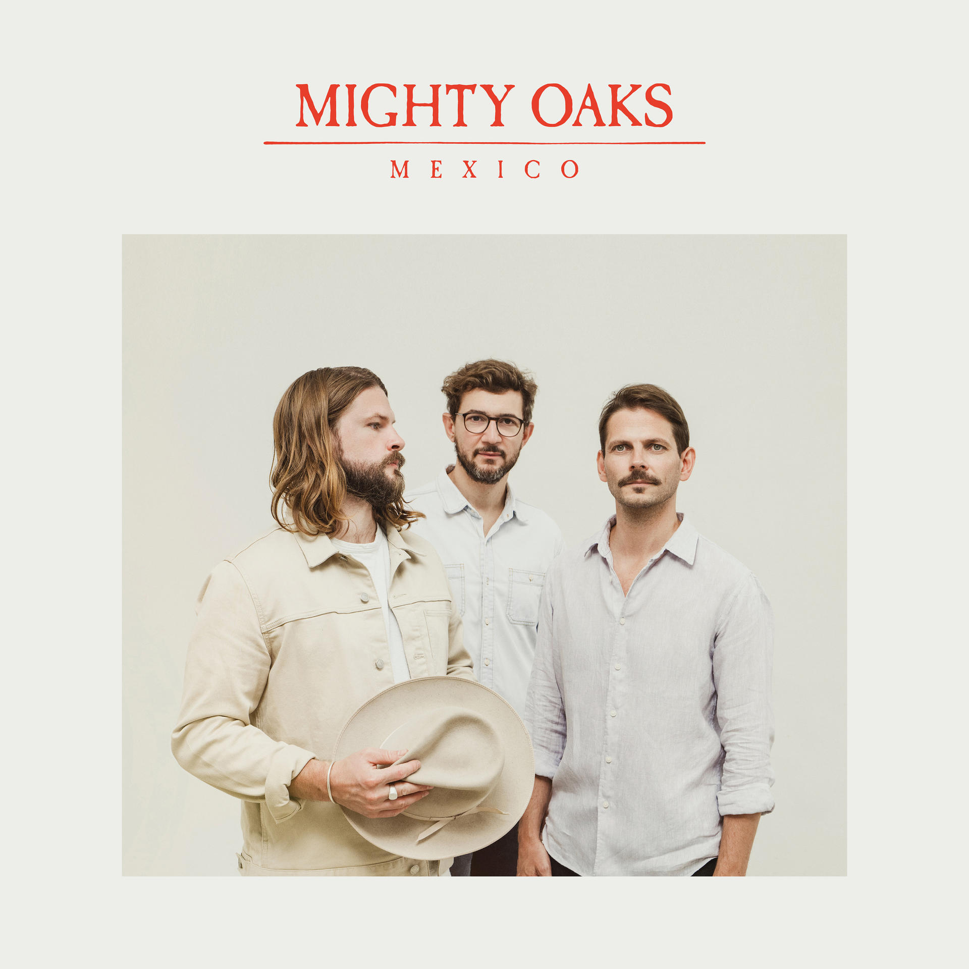 Mighty Oaks Bandmitglieder. Drei Männer in Freizeithemden stehen vor weißem Hintergrund.