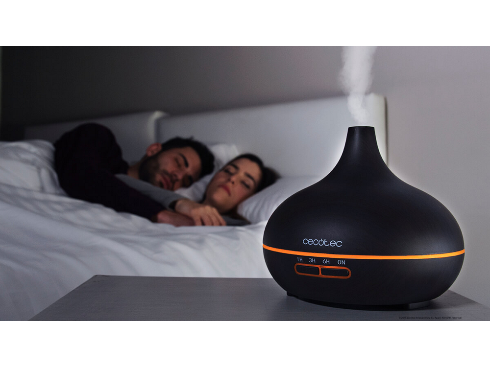 Difusor negro con vapor, y una pareja durmiendo en el fondo. Marca Cecotec.
