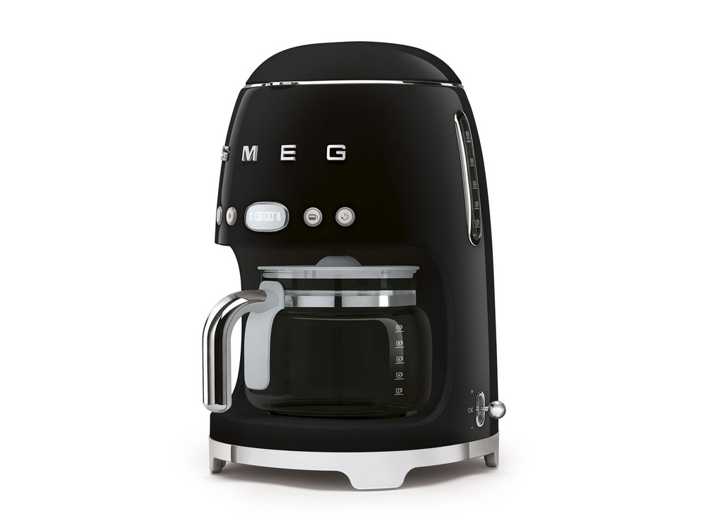 Una cafetera Smeg negra sobre una superficie blanca. Tiene un asa cromada y botones.