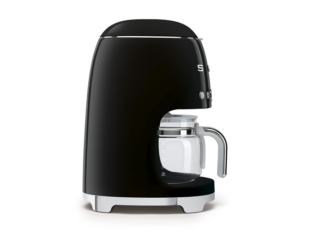 Cafetera Smeg negra con jarra de vidrio. Tiene un diseño retro y está sobre una superficie blanca.