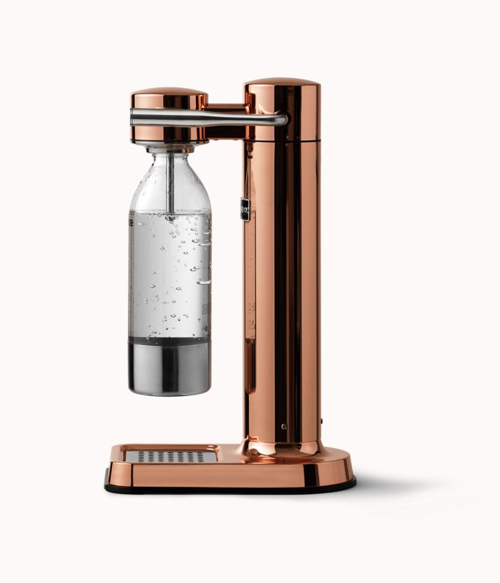 Kupfer-Soda-Maker mit klarer Flasche. Er hat eine Basis und eine hohe Säule.