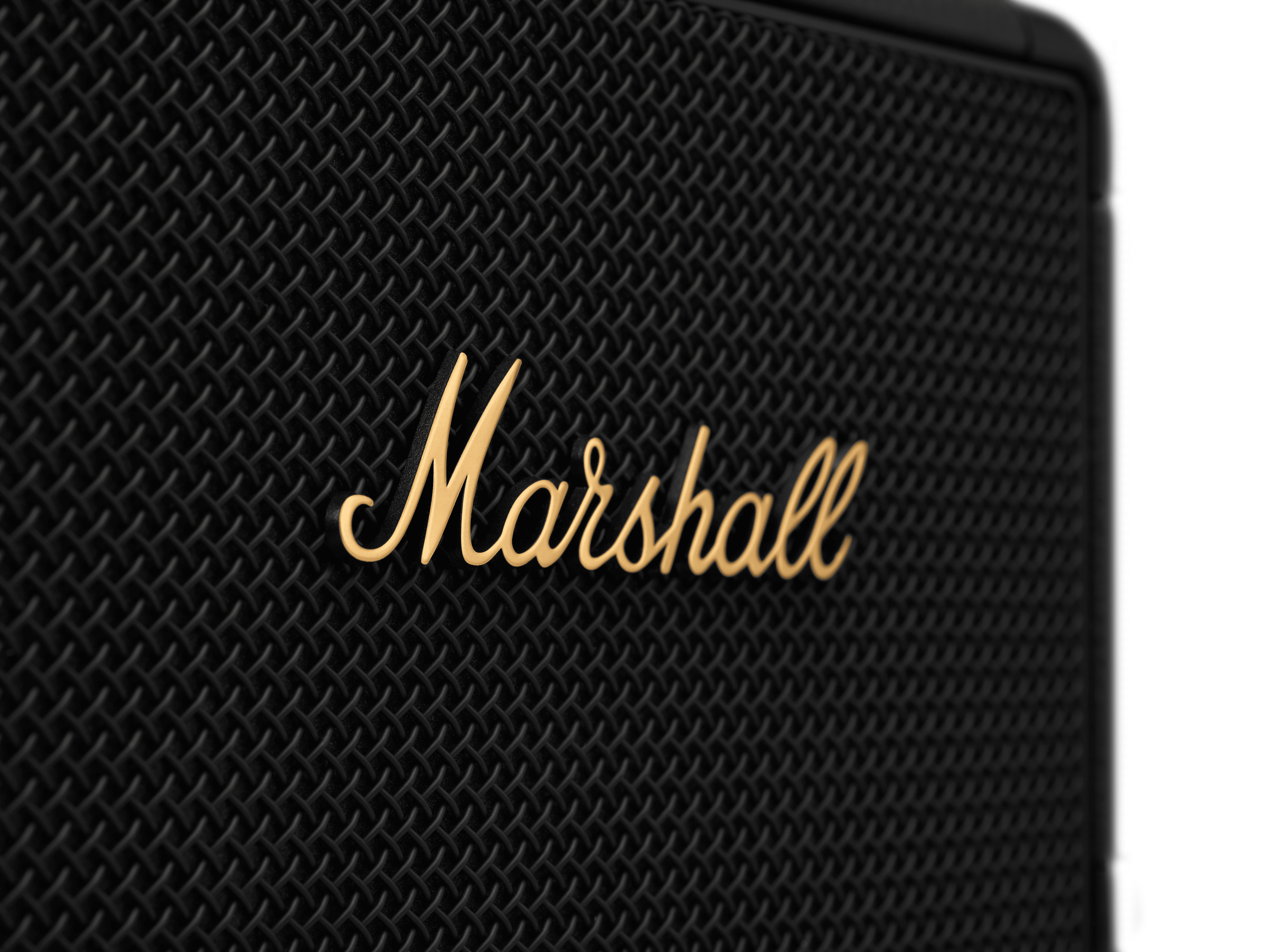 Nahaufnahme eines Marshall-Lautsprechers. Das Logo in goldener Schrift befindet sich mittig auf einer schwarzen, strukturierten Oberfläche.