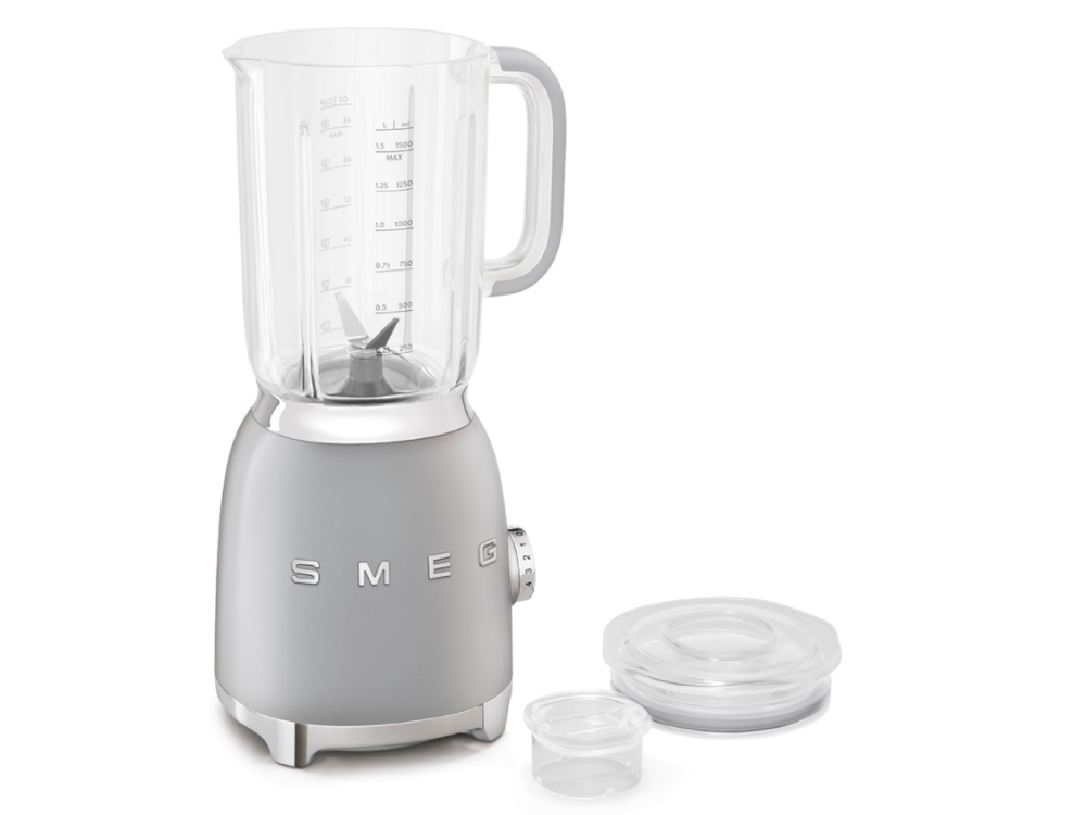 Licuadora Smeg gris con jarra de vidrio, tapa y recipiente pequeño.