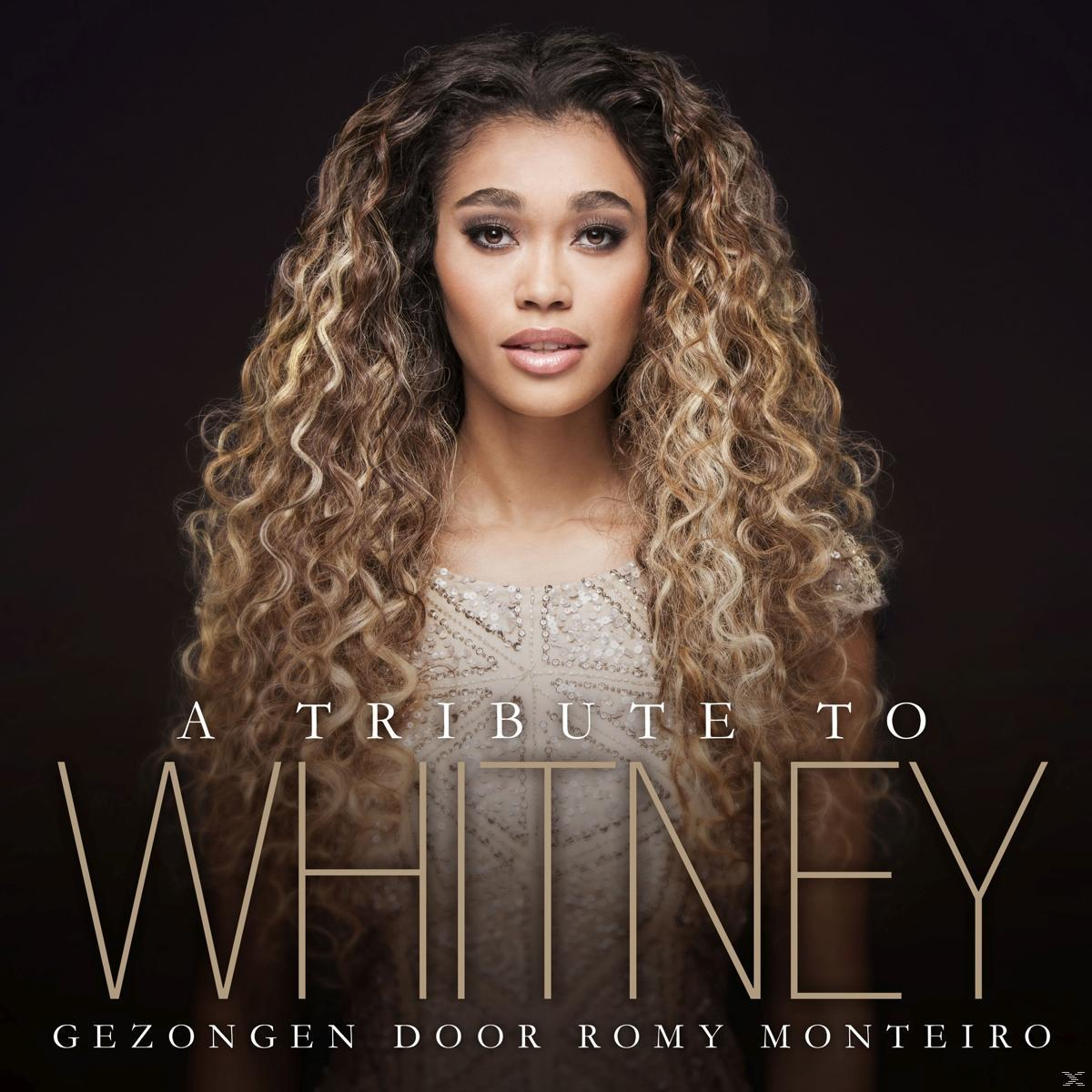 Vrouw met krullend haar. Tekst: 'A Tribute to Whitney' en 'Gezongen door Romy Monteiro' op zwarte achtergrond.