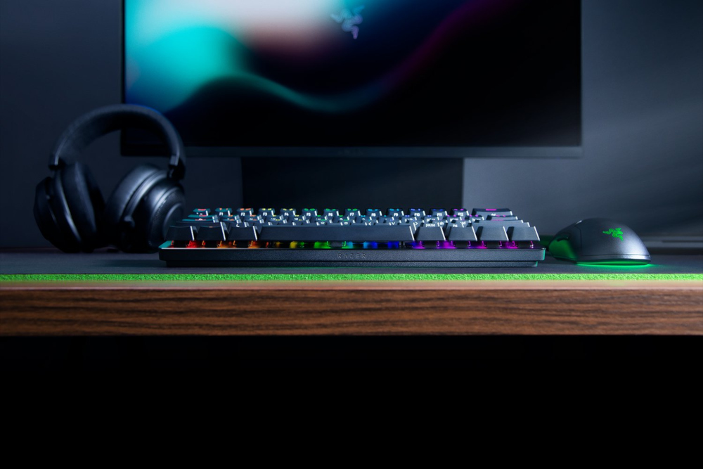 Gaming setup with keyboard, headset, and mouse, on a wood desk.
