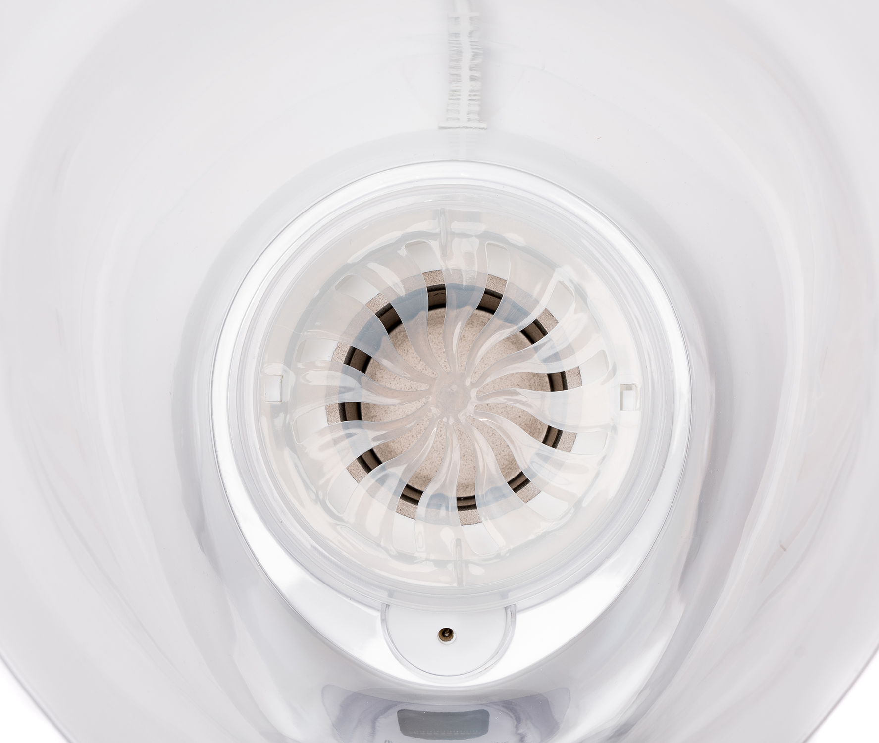 Inside view of a white appliance with a circular, fan-like structure in the center.