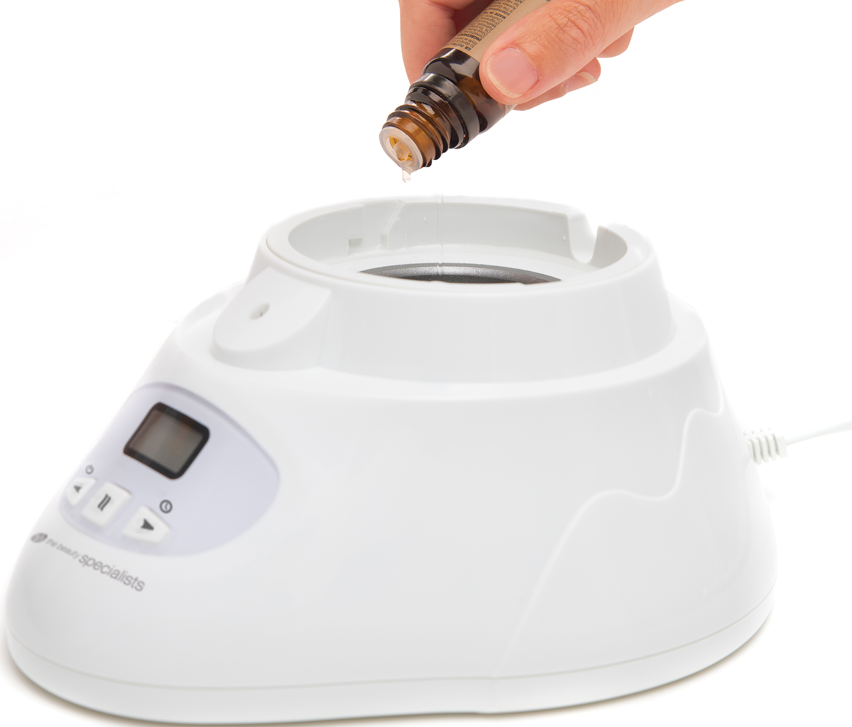 A hand dripping essential oil from a brown bottle into a white aromatherapy device.