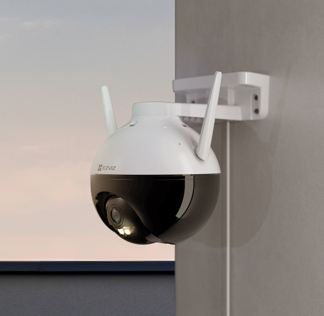 Black and white security camera mounted on a wall.