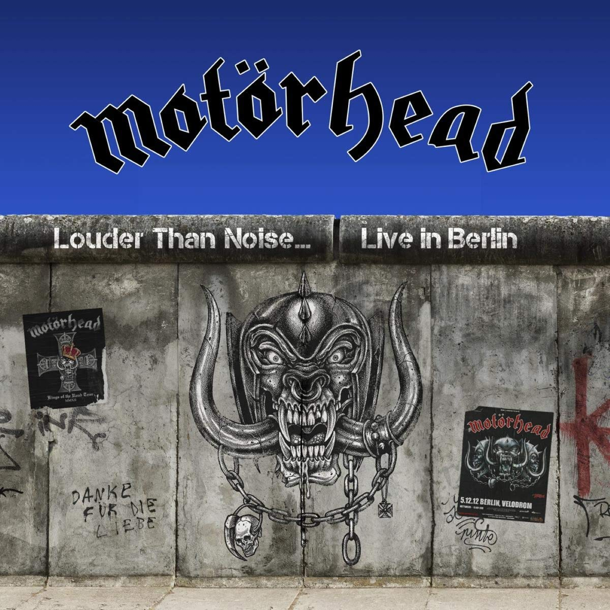 A Motörhead album borítója a berlini falon. A zenekar logója felül, a falon graffitivel és művészettel.