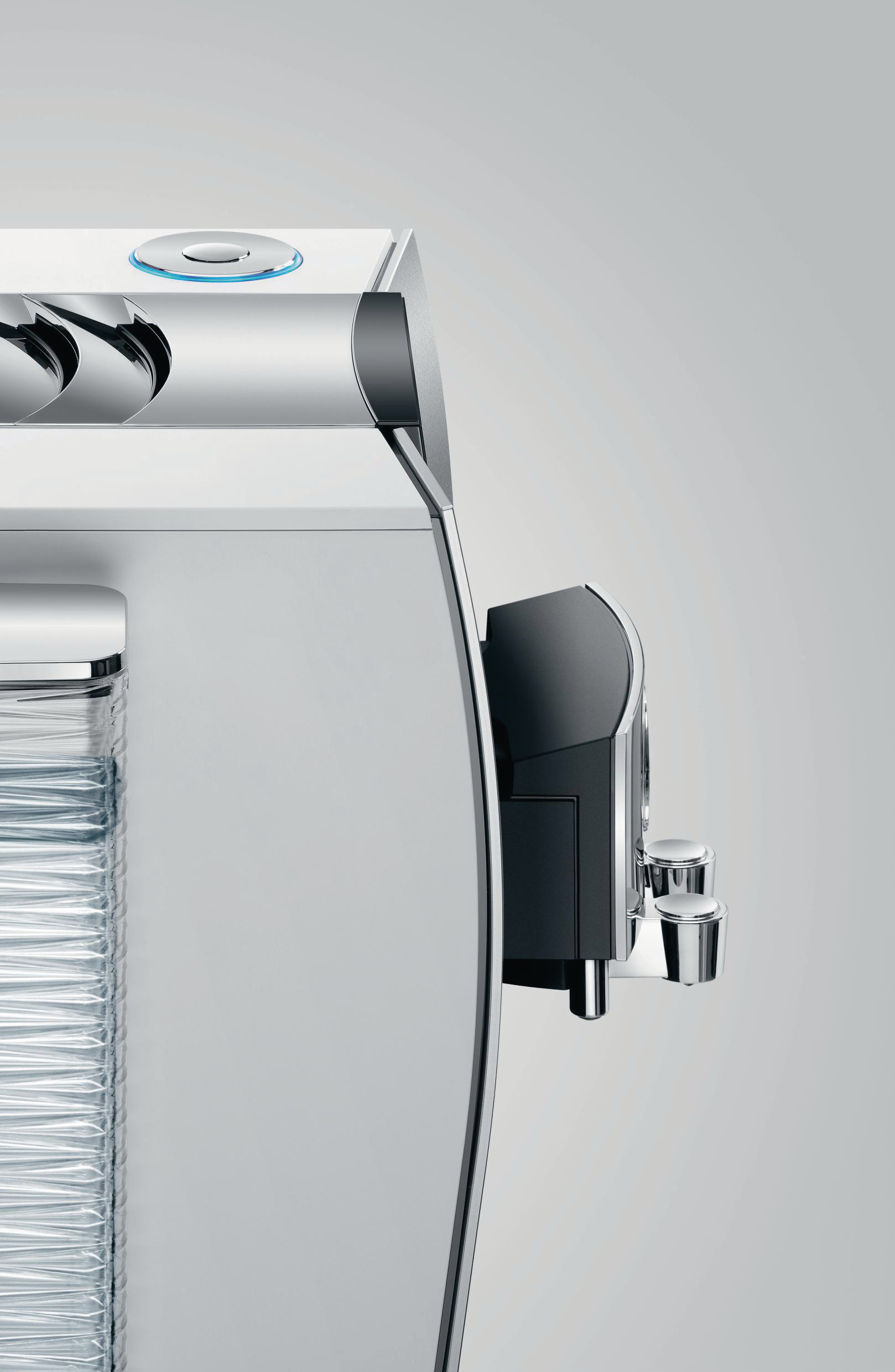 Nahaufnahme einer modernen, silbernen Espressomaschine mit schwarzem Aufsatz und Wassertank.