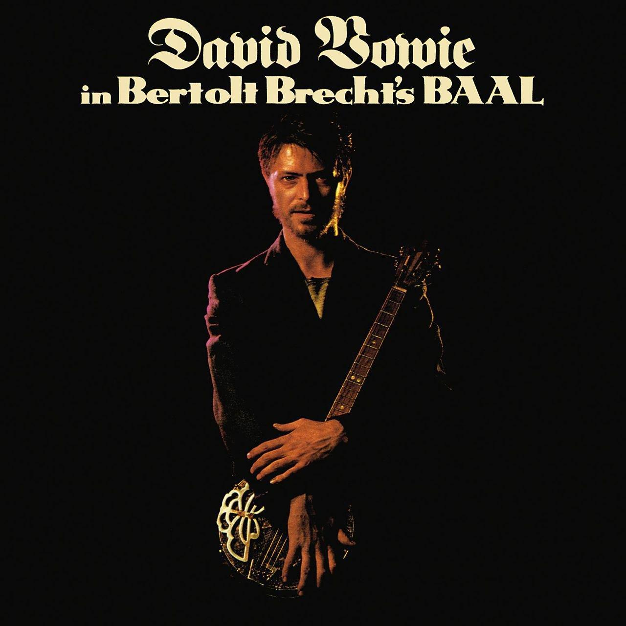 David Bowie fekete háttér előtt, gitárt tart. Felül a szöveg: 'David Bowie'.