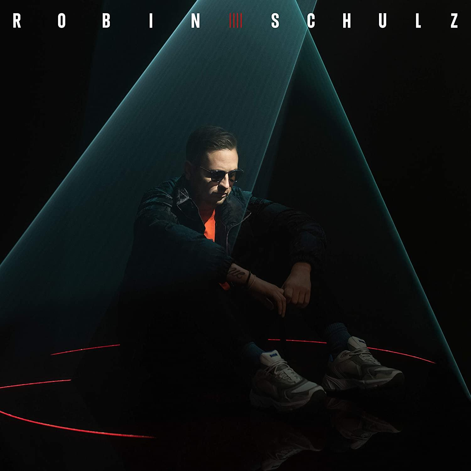Robin Schulz Albumcover. Ein Mann mit Sonnenbrille sitzt mit roten Linien und Lichtstrahlen auf dunklem Hintergrund.