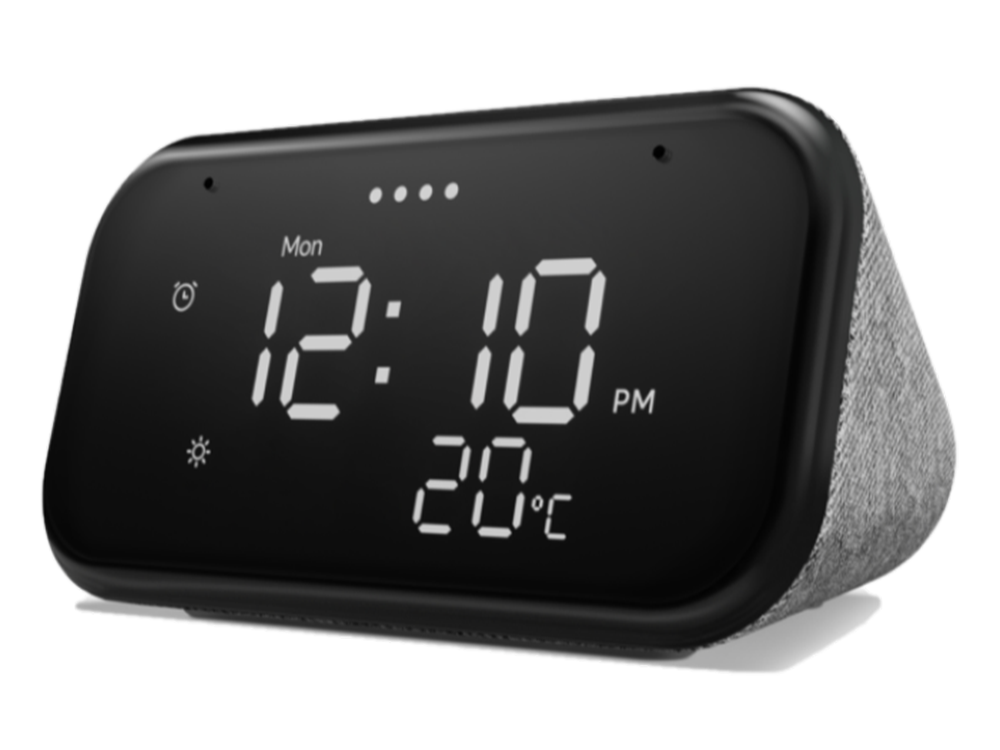 Reloj despertador digital negro que muestra 12:10 PM y 20°C. El reloj tiene un lado de tela gris.