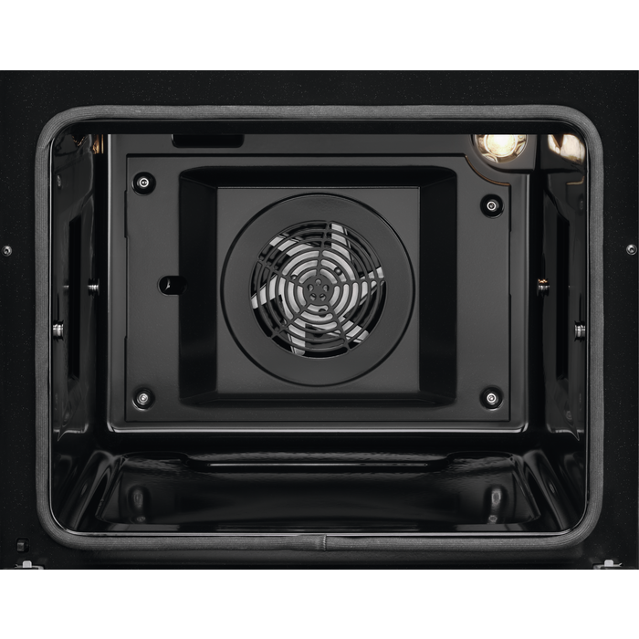 Inside view of a black oven with a fan and a light.