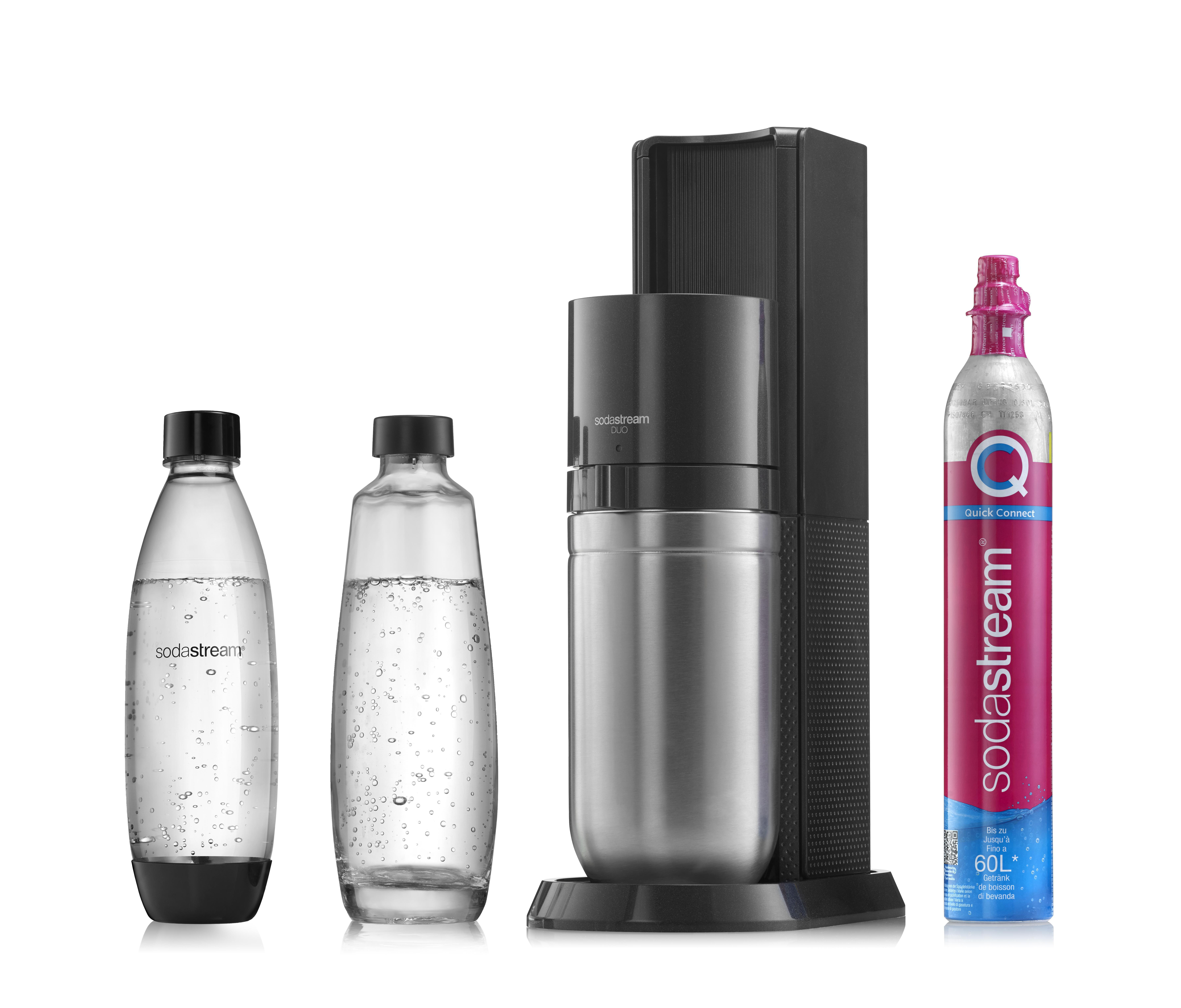 SodaStream-Maschine, Flaschen und CO2-Zylinder. Maschine ist schwarz und silber. Flaschen klar mit schwarzen Deckeln.