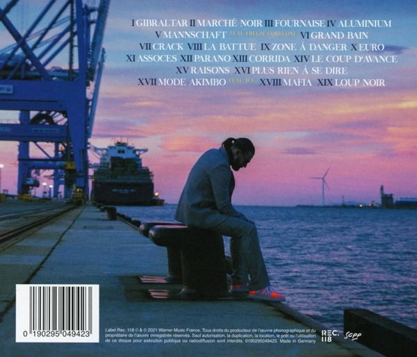 Albumcover mit einem Mann im Anzug, der sitzt. Industrieller Hintergrund mit Schiffen und Wasser.
