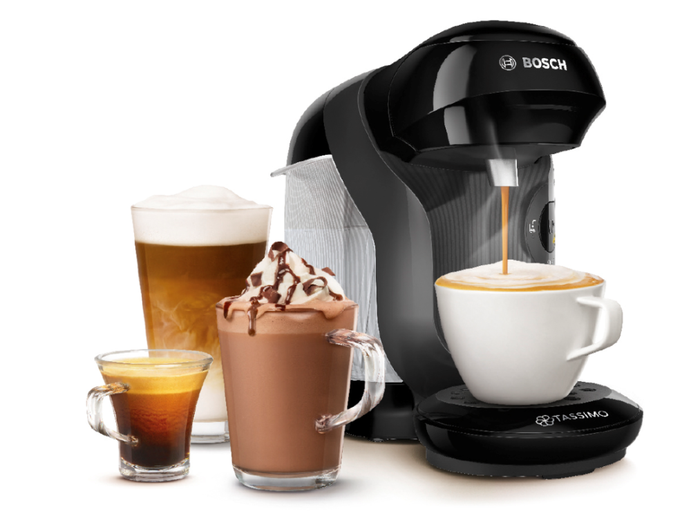 Una cafetera con cuatro tazas de café. Uno es latte, uno es espresso y dos son moca.