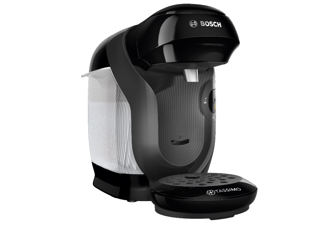 Una cafetera Bosch Tassimo negra sobre una superficie blanca. Está en ángulo hacia la derecha.