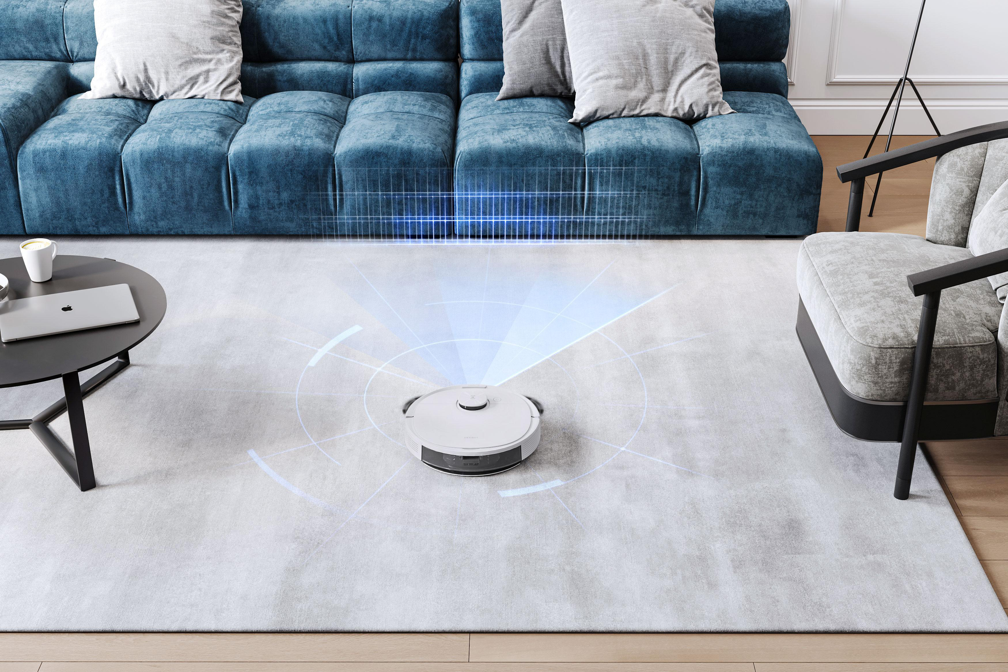 Roboter-Staubsauger auf einem Teppich. Ein blaues Diagramm wird auf den Boden projiziert. Sofa und Stuhl im Hintergrund.