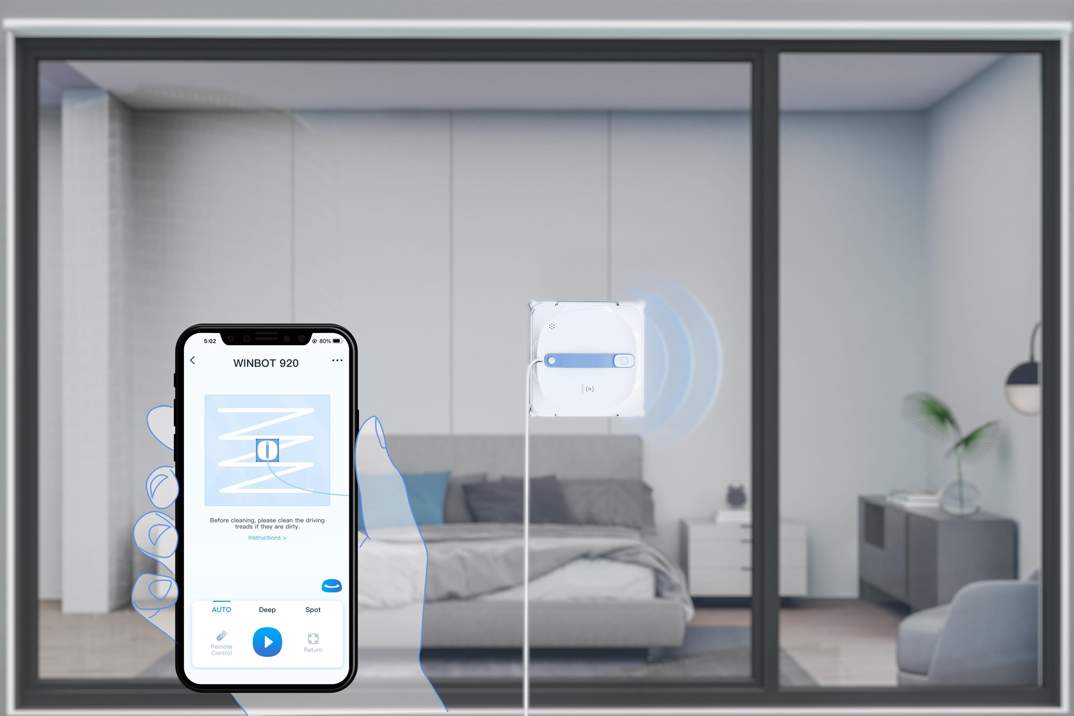 Eine Person benutzt ein Telefon, um einen Fensterputzroboter zu steuern.