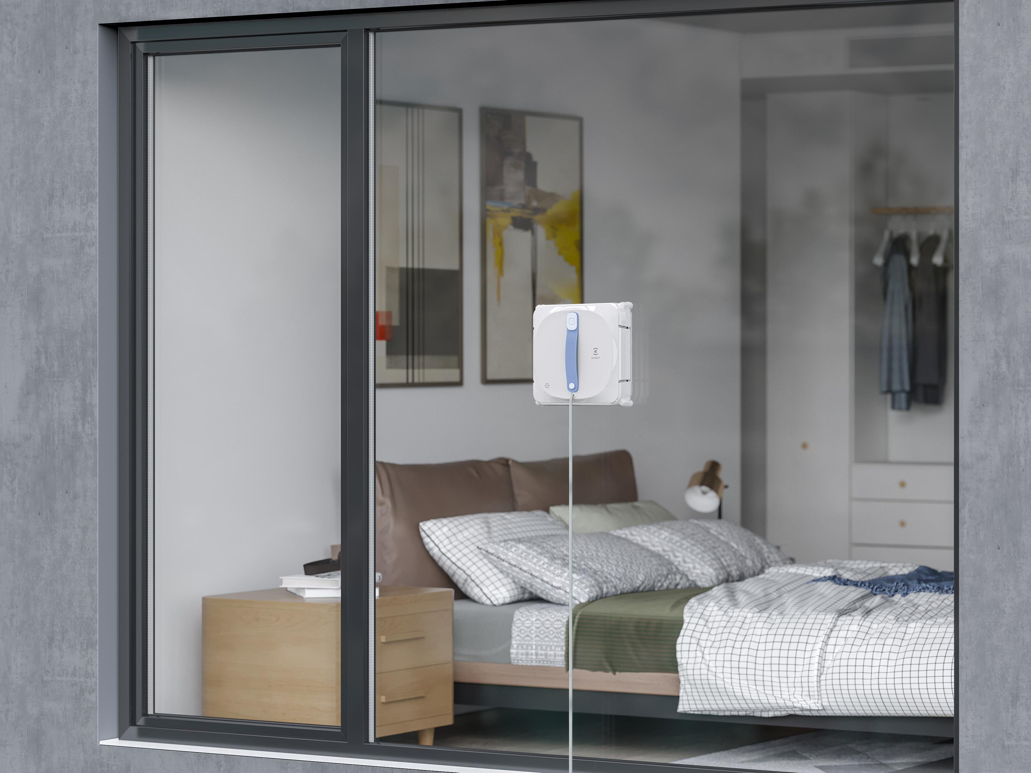 Ein Fensterputzroboter ist an einem Schlafzimmerfenster befestigt.