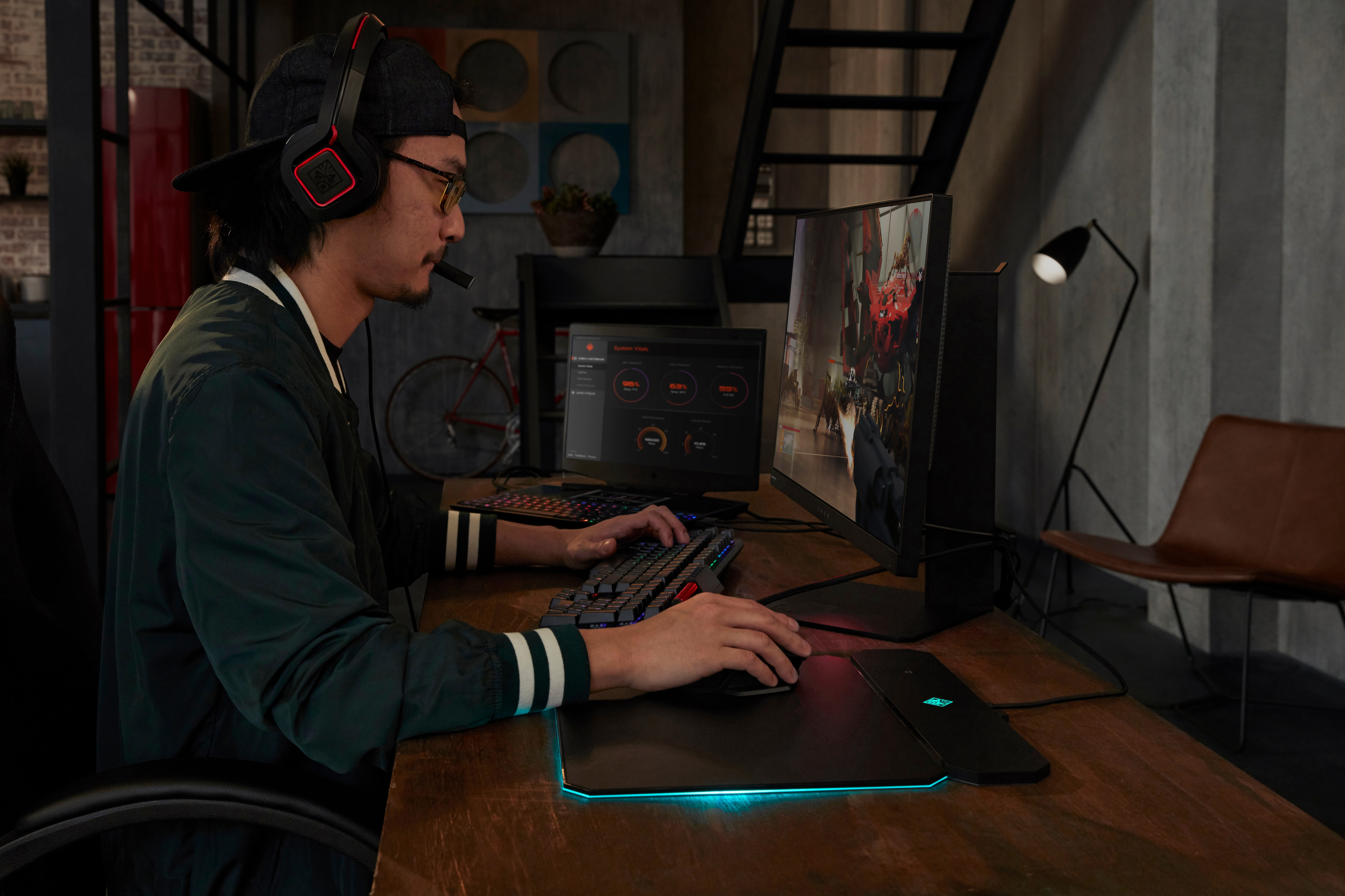 Jugador en el escritorio, auriculares, monitor y configuración de juego visible.