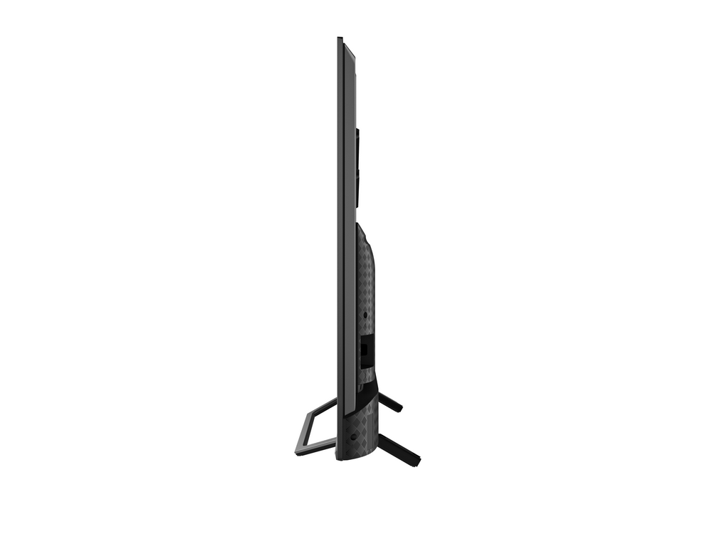 Una vista lateral de un televisor negro sobre un fondo blanco. Tiene un soporte.