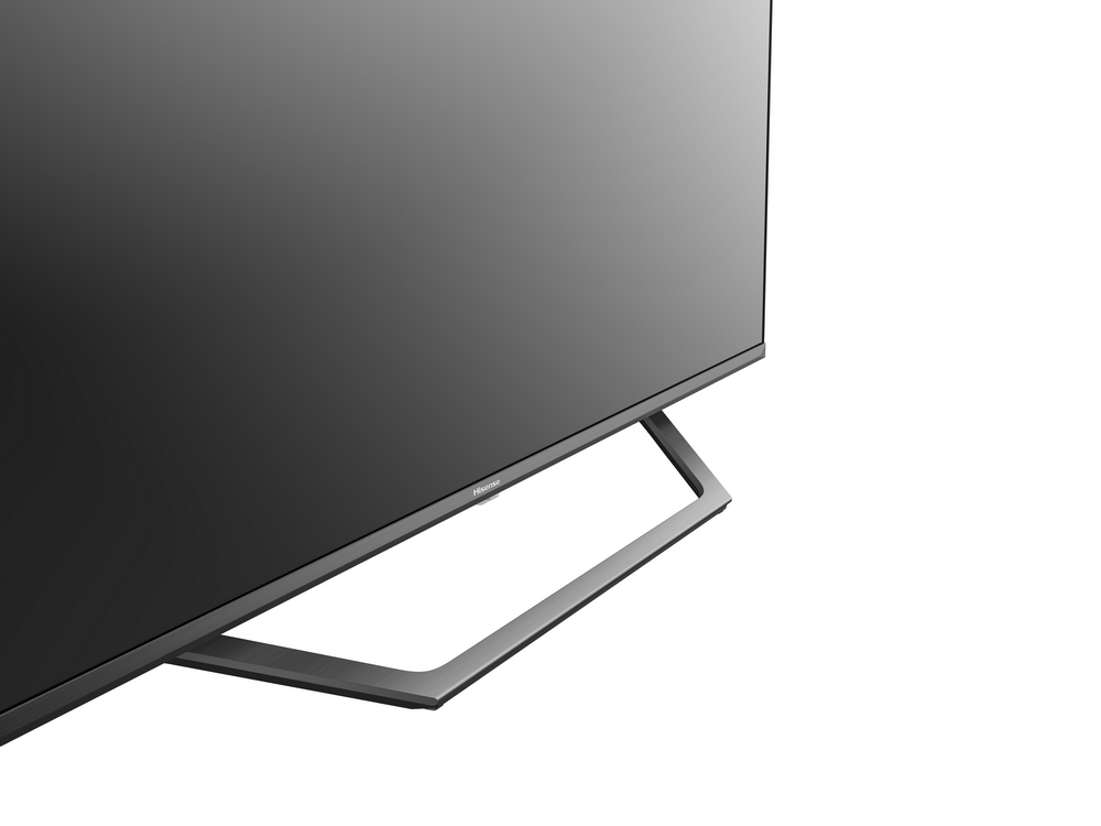 Primer plano de un televisor negro con soporte plateado sobre blanco.