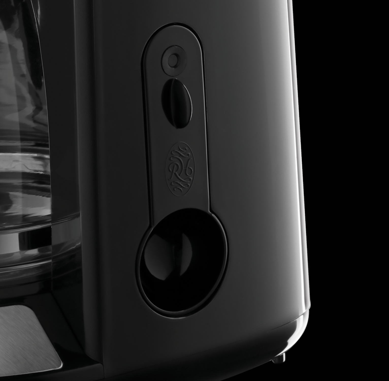 Close up of a black coffee machine's side with a glossy, modern design.