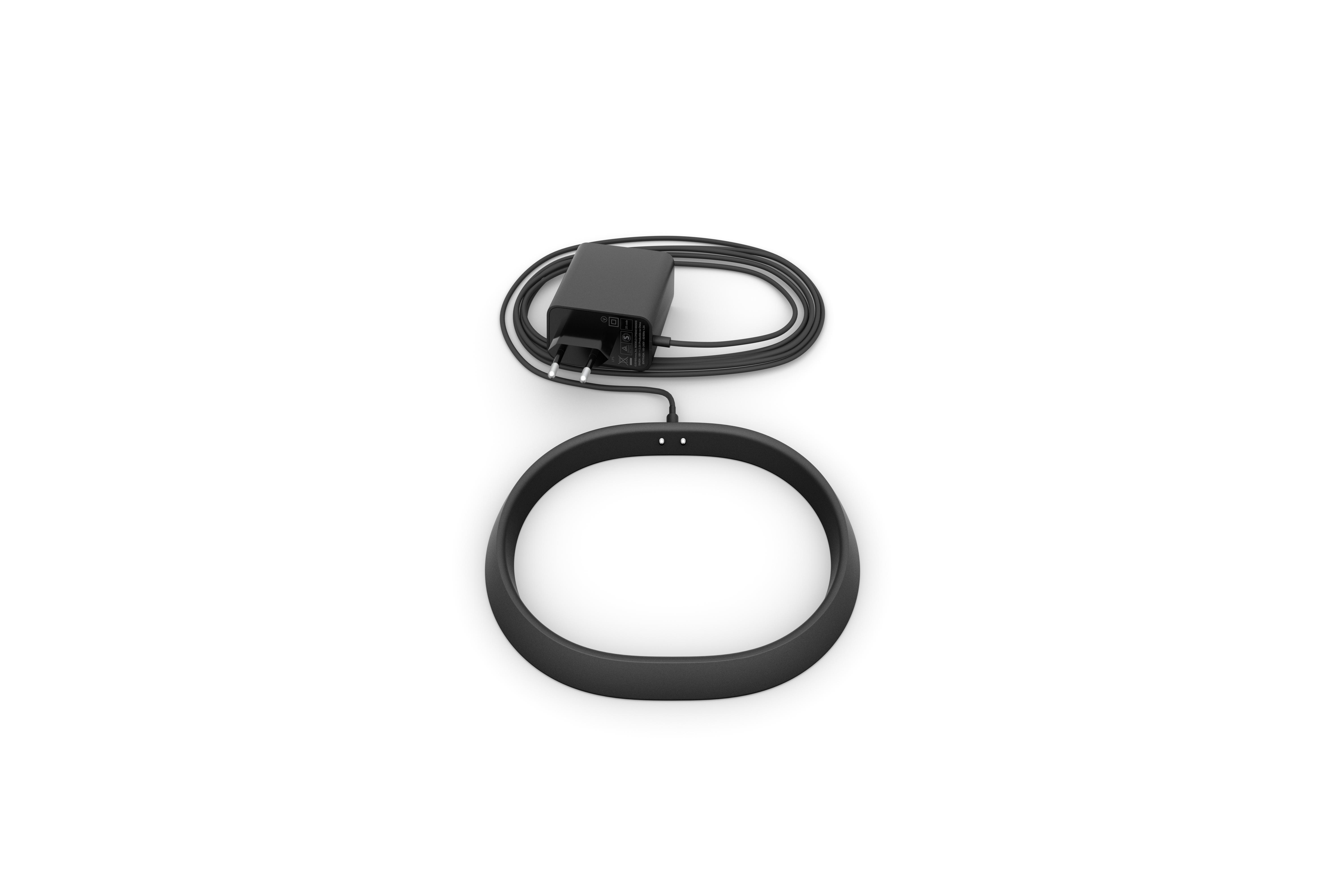 Ein schwarzes ringförmiges Gerät mit Ladekabel und Netzteil auf weißem Hintergrund.
