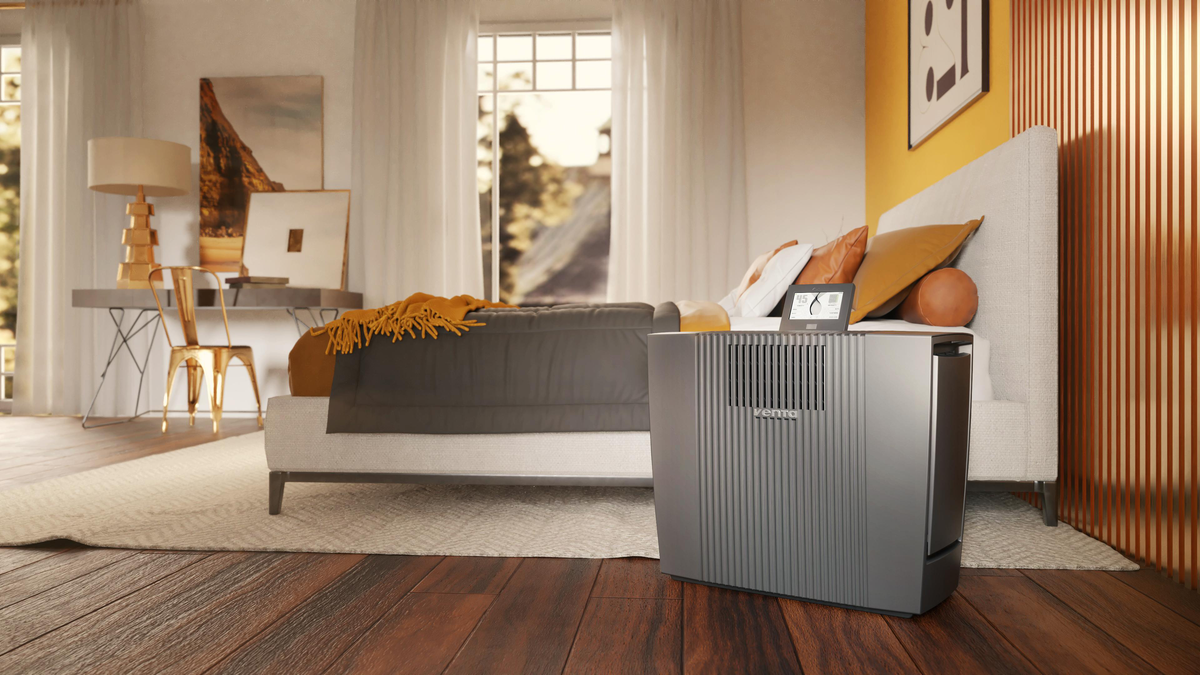 Ein Schlafzimmer mit Bett, Luftbefeuchter, Schreibtisch und Kunstwerken.
