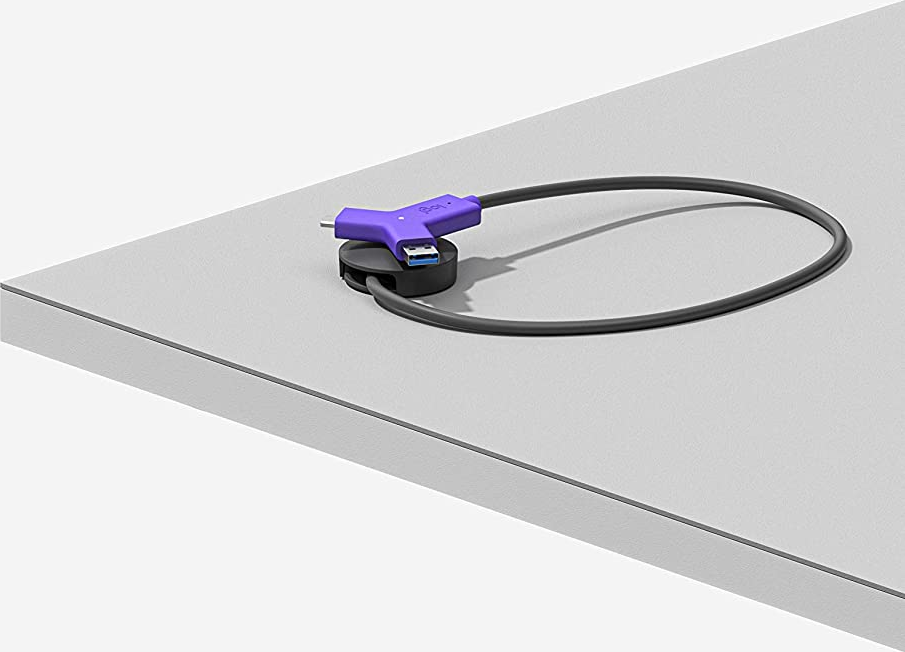 Un hub USB viola e nero su una scrivania, con un cavo che forma un anello.