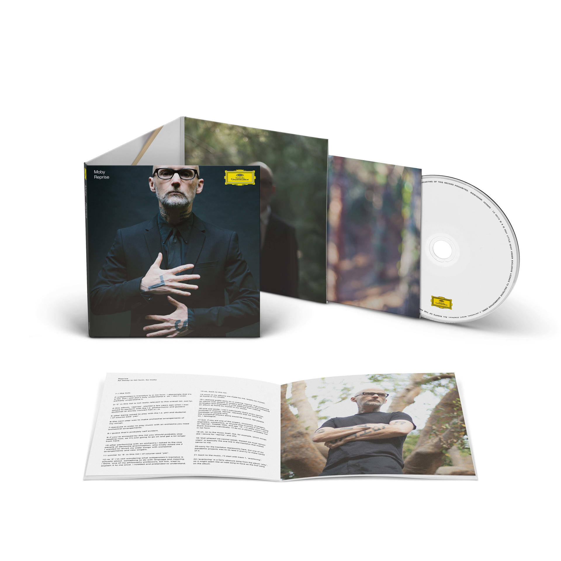 Albumcover mit Moby. Moby im schwarzen Anzug, weißer Brille und Tattoos. Geöffnetes Booklet und CD sichtbar.