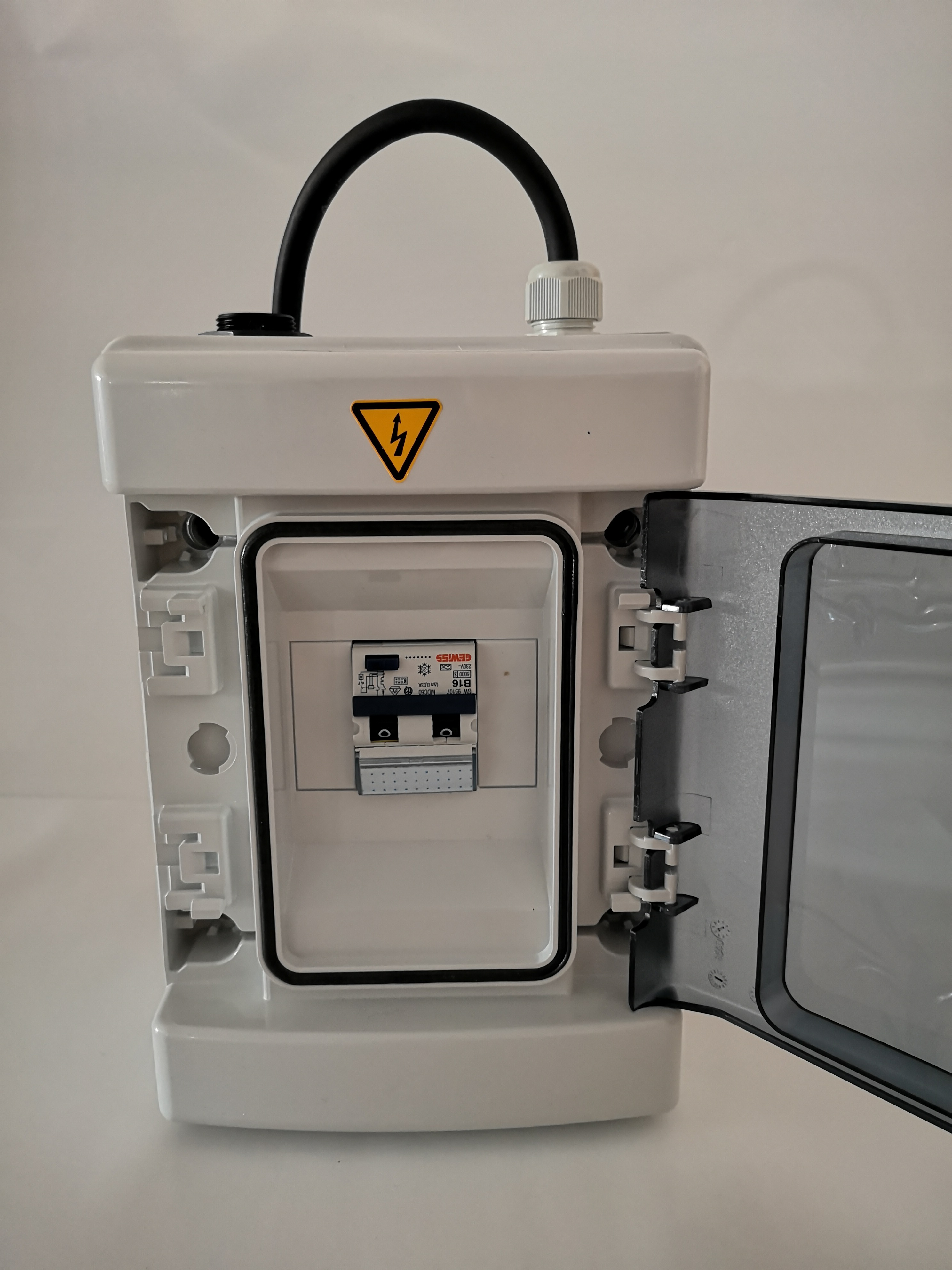 Weißer Elektrokasten mit offener Tür. Enthält elektrische Komponenten. Weißer Hintergrund.
