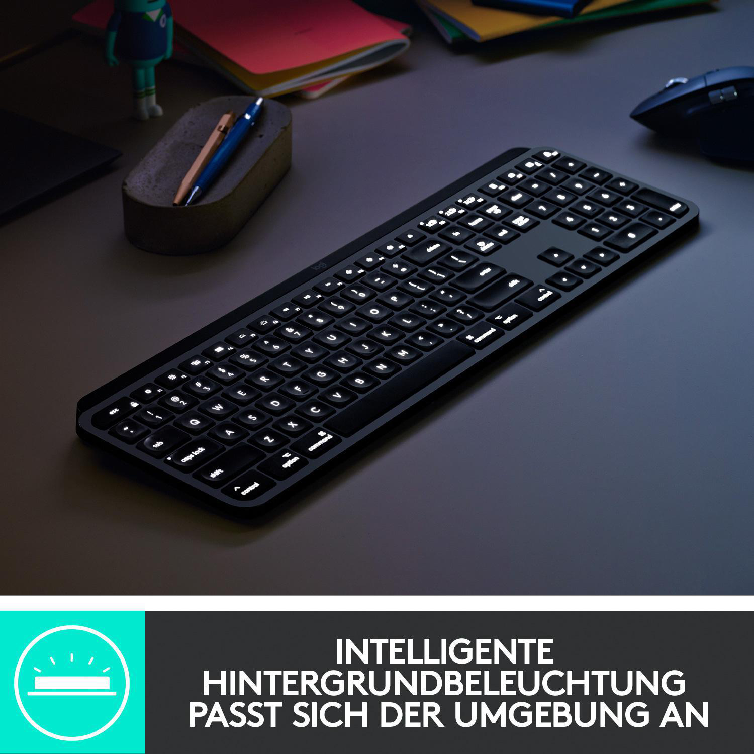 Beleuchtete schwarze Tastatur auf einem Schreibtisch mit Stift und Maus.
