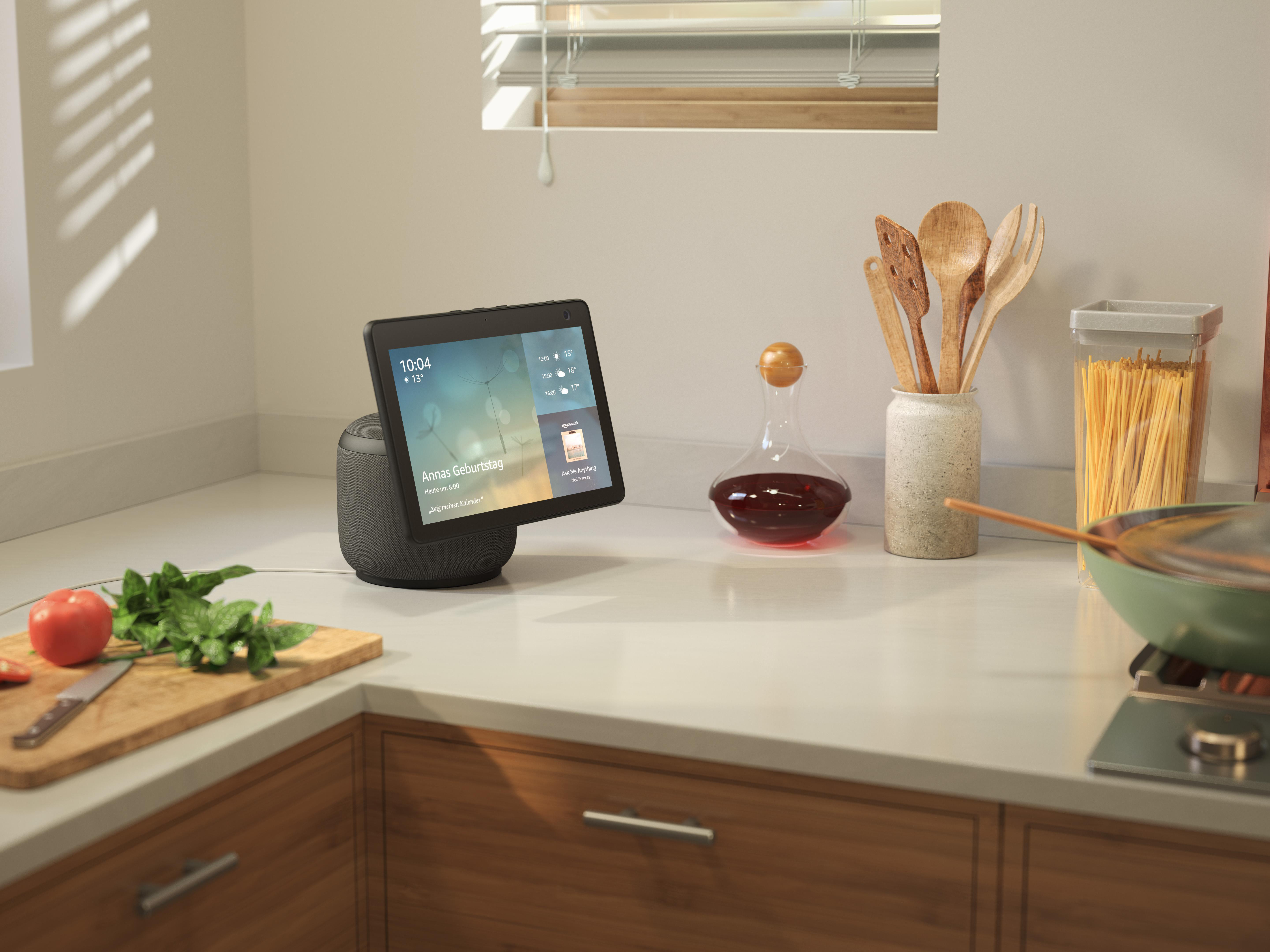 Küchentheke mit Smart Display, Gemüse und Küchenutensilien.
