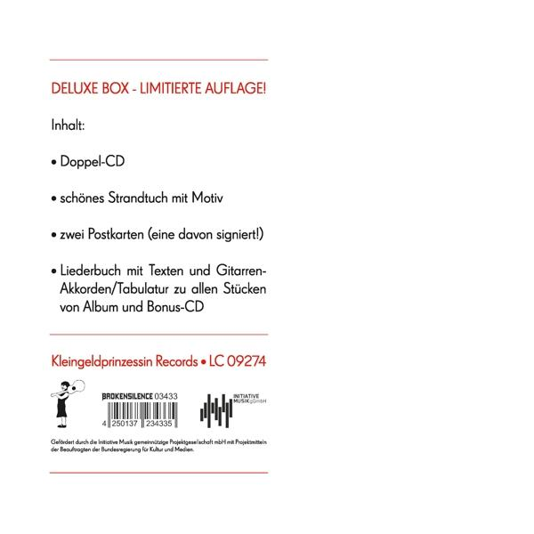 Inhalt der Deluxe-Box mit Text, einschließlich CD, Strandtuch und Postkarten.