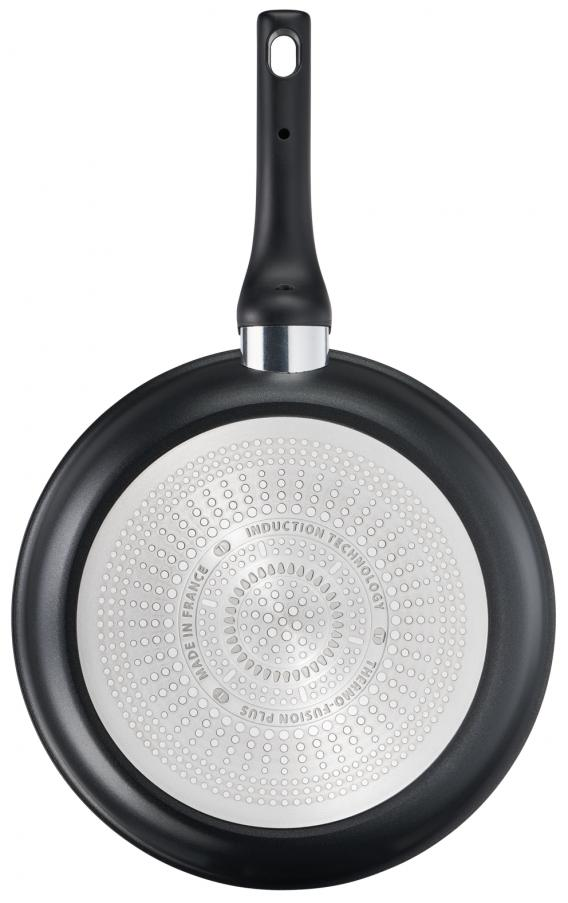 The bottom of a black frying pan with a handle.