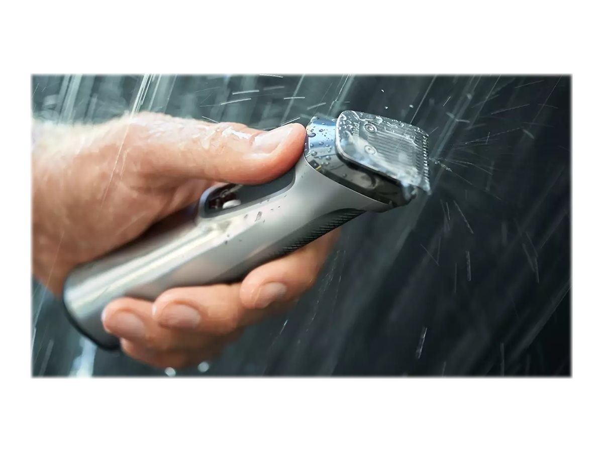Hand hält einen silber-schwarzen Elektrorasierer unter Wasser.