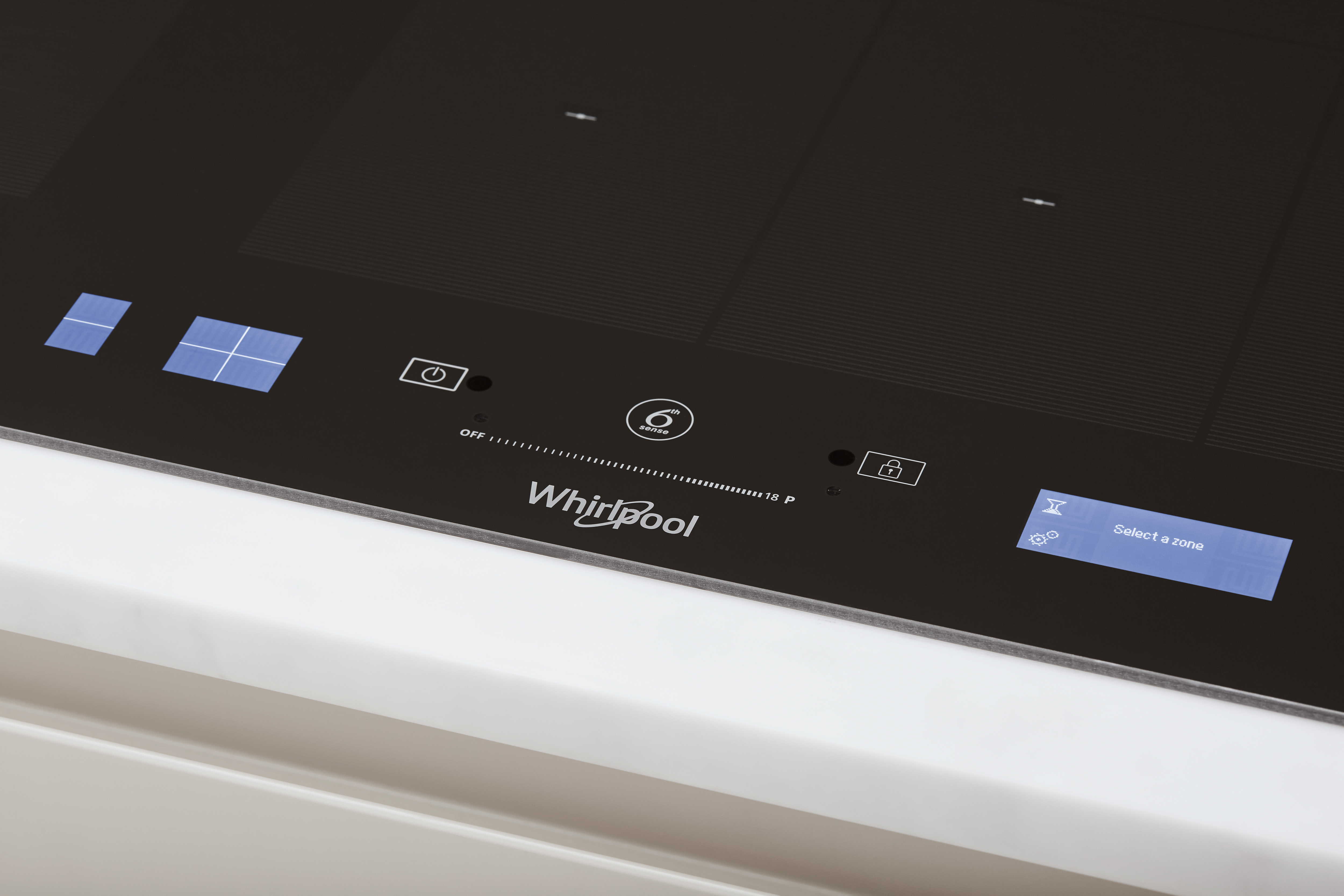 Fekete indukciós főzőlap közelről, érintésvezérlőkkel és Whirlpool logóval.